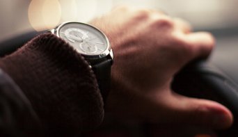 Мужчина одной рукой деожится за руль Мужчина держится за руль